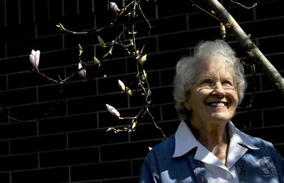 Jean Smart stands beneath a blooming magnolia tree at North Idaho College on April 24. Smart has been a Master Gardener since 2000. She and her husband, Harold, have lived in North Idaho since 1993. (Kathy Plonka / The Spokesman-Review)