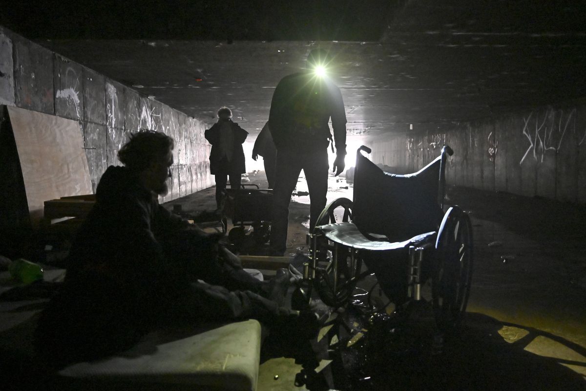 FILE - In this Dec. 5, 2020, file photo, a man who identified himself as Wheeler, left, speaks with Dave Marlon of CrossRoads of Southern Nevada, during an outreach in the underground tunnels to offer counseling, food and water to the homeless living beneath the city in Las Vegas. When census takers tried to count the nation