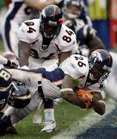 
Denver Broncos running back Tatum Bell dives into the end zone from the 1-yard line for the second of his three touchdowns in a regular-season ending victory over the Chargers on Sunday in San Diego.
 (Associated Press / The Spokesman-Review)