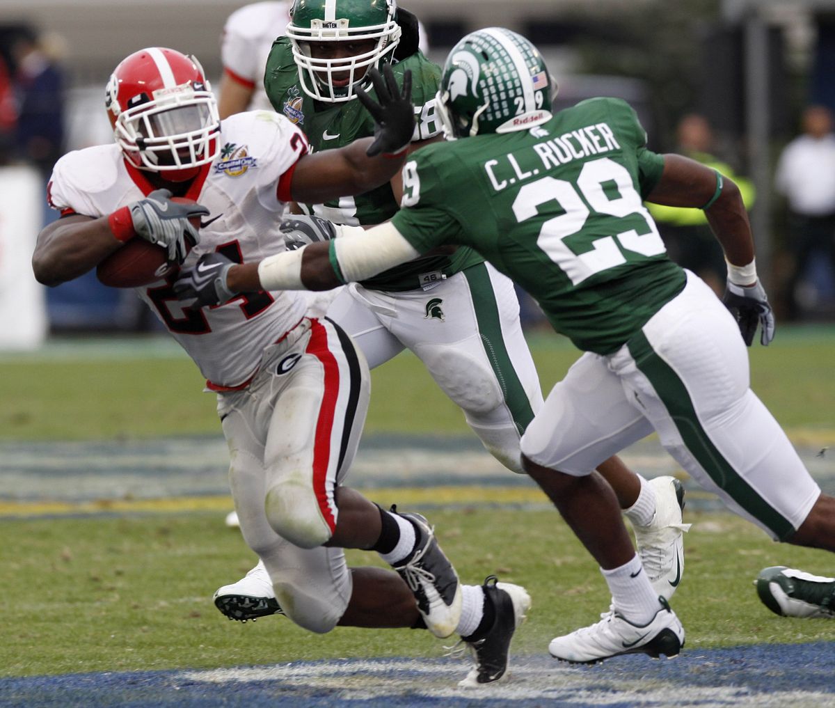 Georgia running back Knowshon Moreno, left, runs for yardage as Michigan State cornerback Chris L. Rucker  gives pursuit.   (Associated Press / The Spokesman-Review)