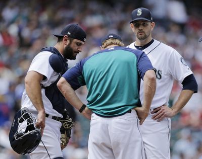 Seattle Mariners pitching coach Mel Stottlemyre, center, talks on the mound with starting pitcher James Paxton and David Freitas in the sixth inning just before giving up a home run to Colorado’s Noel Cuevas on July 7 in Seattle. (John Froschauer / AP)