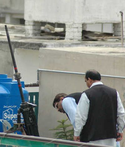
Ssecurity officials examine an anti-aircraft gun found Friday on the roof of a house in Rawalpindi, Pakistan. Associated Press
 (Associated Press / The Spokesman-Review)