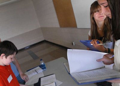 Greenacres Middle School student Kendra Sherrill, center, smiles at her teammate Katie Mandler, after making a point about school security during a debate against Horizon Middle School team member Valentin Godun. 
 (Brian Plonka / The Spokesman-Review)