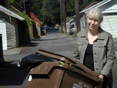 
Corbin Park resident Gina McKenzie and a group of others object to moving their trash from the alley to their front street for pickup.  
 (Holly Pickett / The Spokesman-Review)