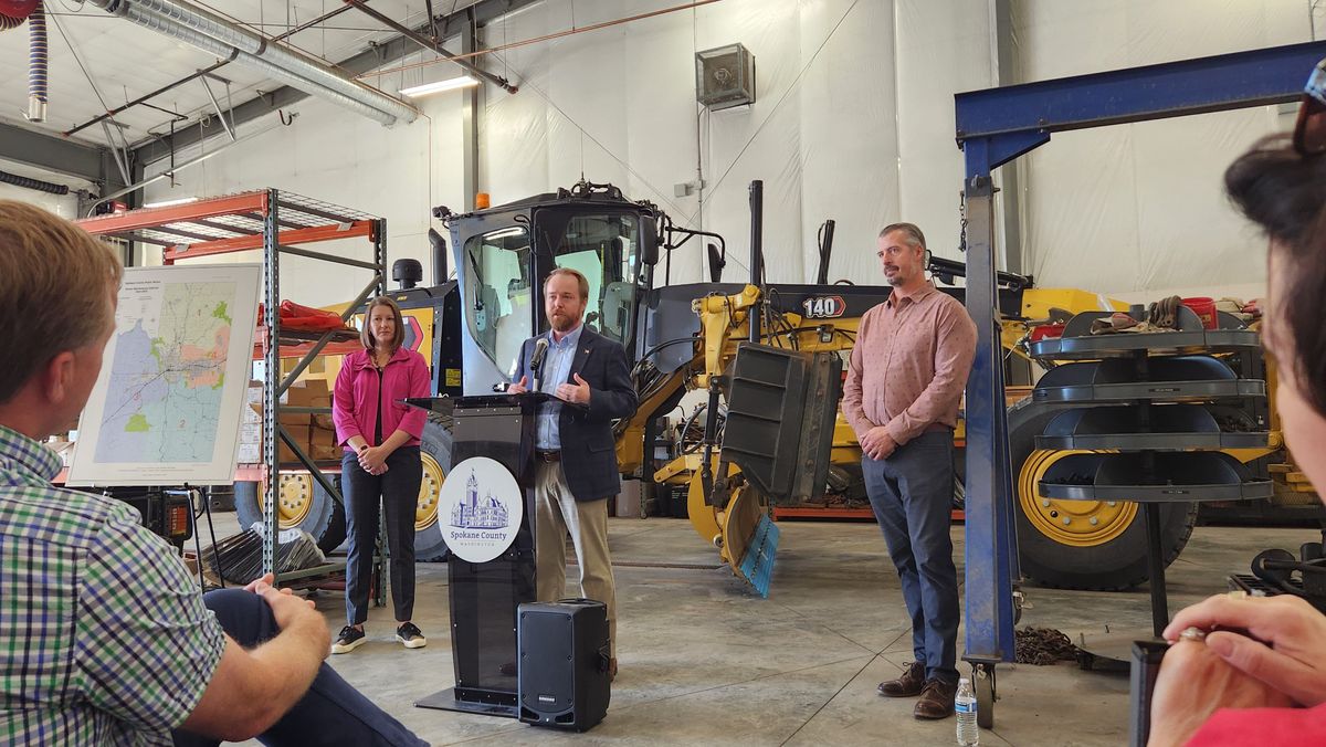 Spokane County Commissioner Josh Kerns addresses media Thursday in front of a snow plow equipped with snow gates and Sharq Edges. The National Weather Service is expecting a weak La Niña weather pattern to bring more snowfall to the area than usual this coming winter.  (Cannon Barnett / The Spokesman-Review)
