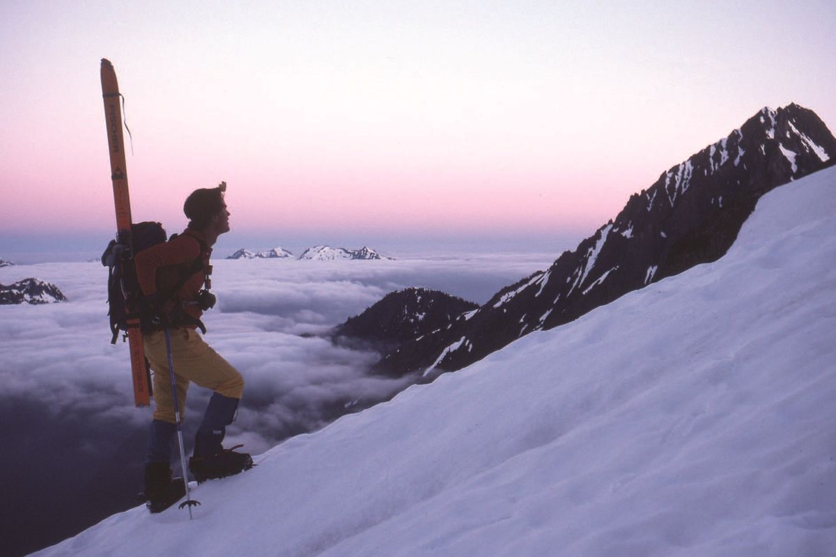 Carl Skoog pauses at dawn near Cache Col on the Ptarmigan Traverse in 1988.  (Photo courtesy of Lowell Skoog)