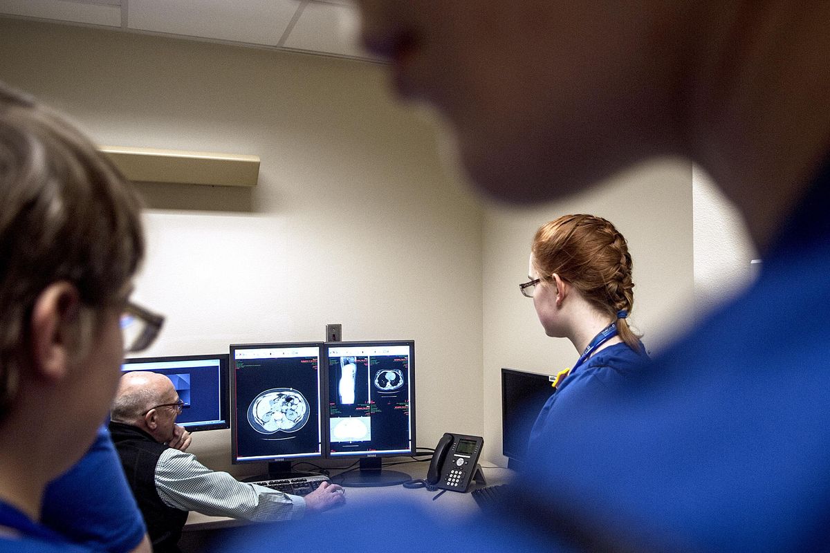 Dr. Randi Hart, center left, talks with students from Pines Middle School about an X-ray during career day. (Kathy Plonka)