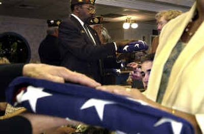 
Doug Jones, center, and other members of the Veterans of Foreign Wars Post No. 51 present flags to family members of deceased veterans at the Spokane Veterans Home on Tuesday.
 (Jed Conklin / The Spokesman-Review)