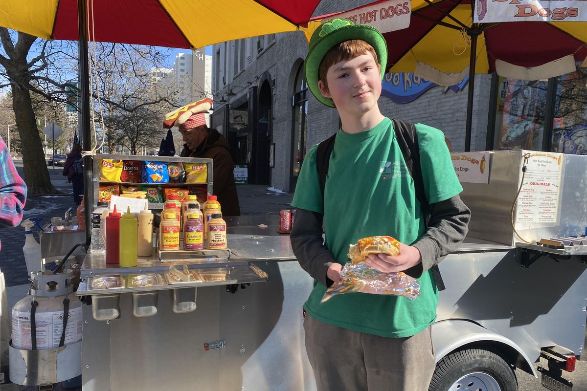 Chauncey Scheller, 15, enjoys a hot dog outside of O