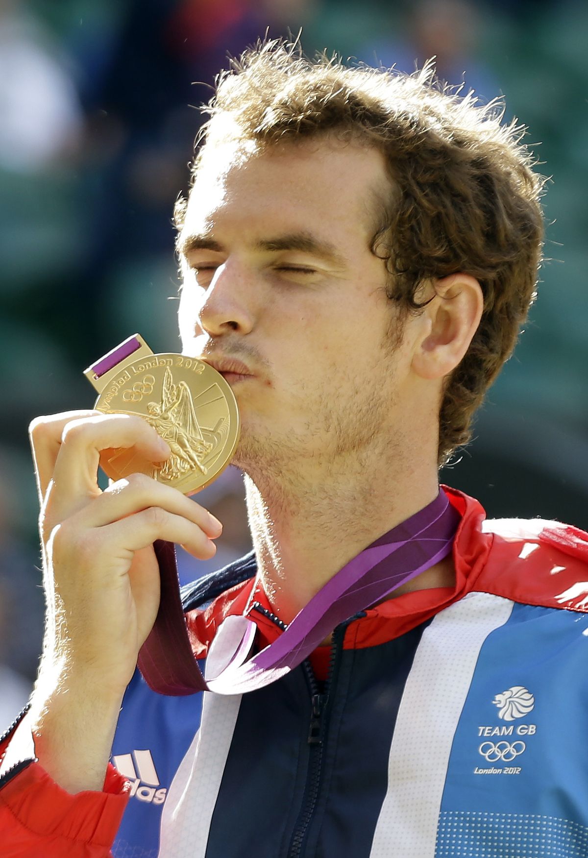 Britain’s Andy Murray kisses his gold medal on the podium at Wimbledon on Sunday. (Associated Press)