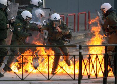 Riot police try to avoid a petrol bomb during clashes in central Athens on Sunday.  (Associated Press / The Spokesman-Review)