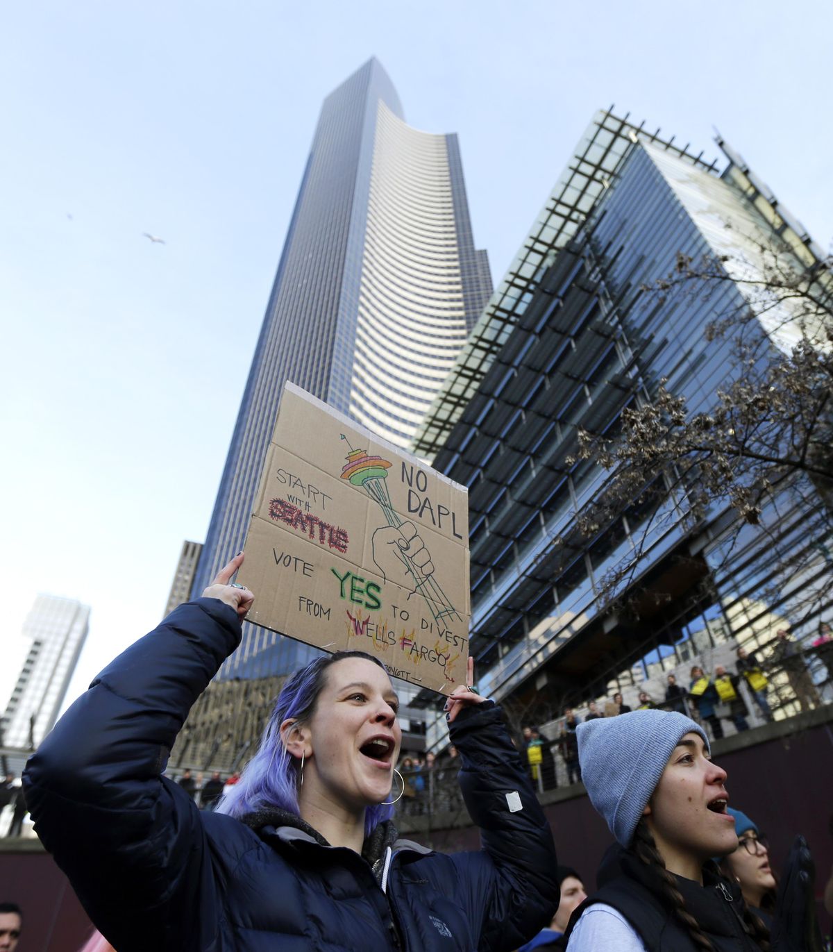 Lela Wulsin, of Seattle, cheers as she holds a sign that reads “No DAPL Start With Seattle” as she takes part in a protest against the Dakota Access Pipeline and the city of Seattle’s use of Wells Fargo Bank, due to the bank’s role in lending funds to finance the pipeline’s construction, Wednesday, Feb. 1, 2017, at City Hall in Seattle. (Ted S. Warren / Associated Press)