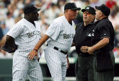 
Rockies manager Clint Hurdle stands between Ray King as the two argue with home plate umpire Travis Reininger, far right, and crew chief Derryl Cousins. 
 (Associated Press / The Spokesman-Review)