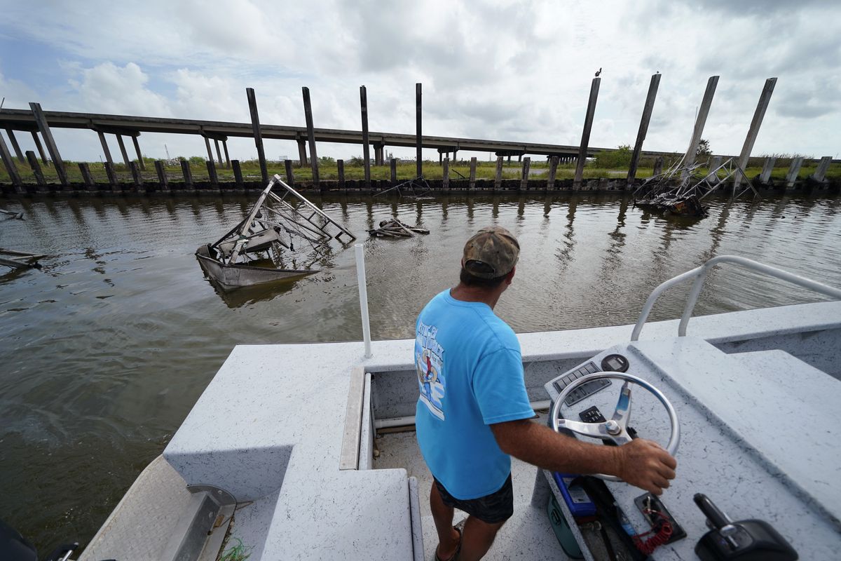 Frank Jurisich motors past shrimp boats that caught fire and burned during Hurricane Ida, as he and his brother go check on their oyster beds in Plaquemines Parish, La., Monday, Sept. 13, 2021. Ida