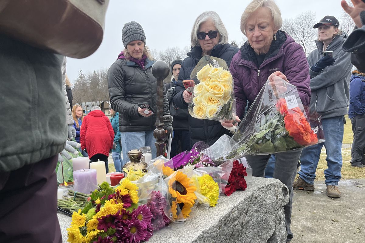 Attendees place flowers at a vigil at Independence Point on Sunday. The vigil was arranged in memory of Renee Good, a woman shot and killed by an Immigrations and Customs Enforcement agent in Minneapolis on Wednesday.  (Elena Perry/The Spokesman-Reivew)
