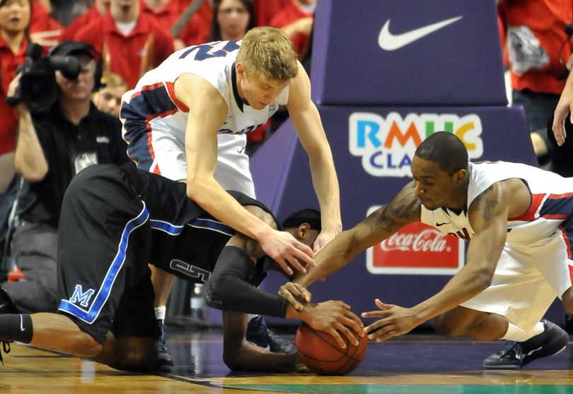 Gonzaga's Mathis Monninghoff, above, and Demetri Goodson, right, dive into to take the ball from Memphis' Will Barton, left, who helped the Tigers past the Bulldogs, 62-58, on Saturday, Feb. 5, 2011, at the Spokane Arena. (Jesse Tinsley / The Spokesman-Review)