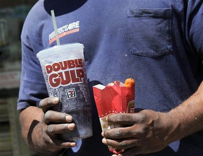 In this May 31, 2012 file photo, a man leaves a 7-Eleven store with a Double Gulp drink, in New York. If New York City bans big sodas, what's next? Large slices of pizza? Double-scoop ice cream cones? Tubs of movie-theater popcorn? The 16-ounce strip steak? Opponents of the proposed ban may use that slippery-slope argument along with other legal strategies to try to block the first-in-the-nation rule. (Richard Drew / AP Photo)