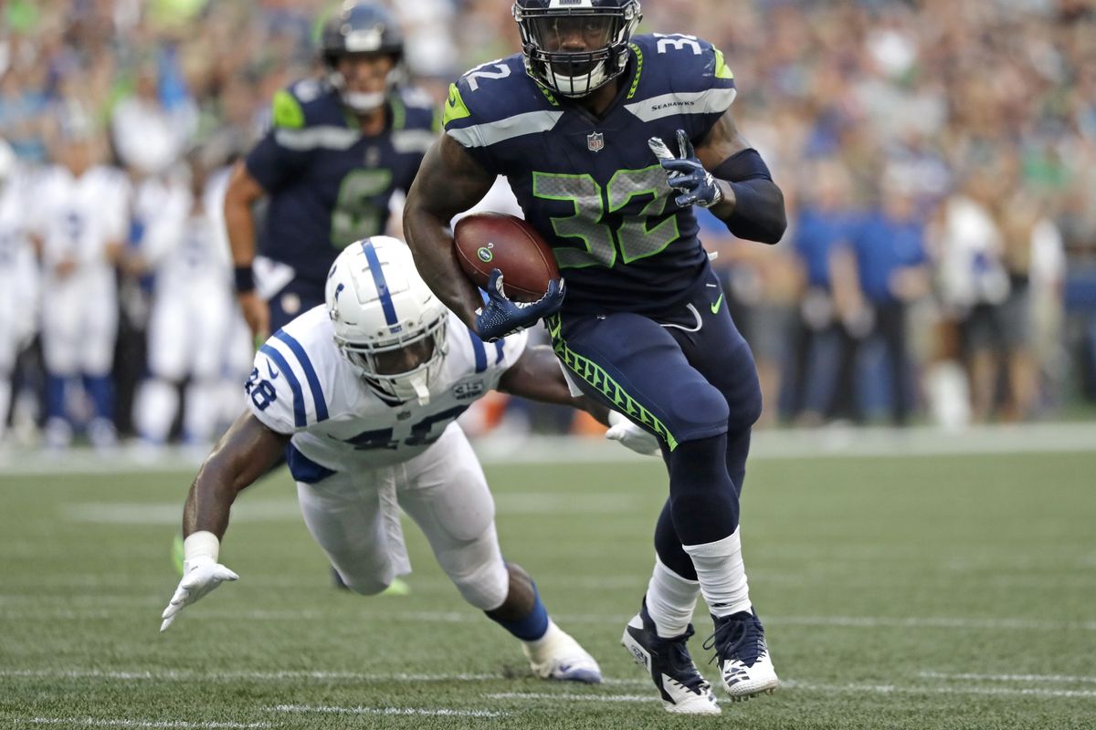 Seattle Seahawks running back Chris Carson outruns a tackle attempt by Indianapolis Colts linebacker Skai Moore during the first half of a preseason game, Aug. 9 in Seattle. (Elaine Thompson / AP)