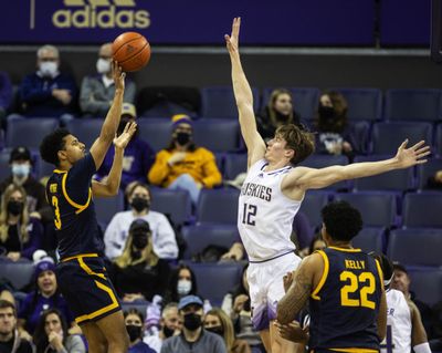 Washington's Jackson Grant comes in to make the block on the shot by Cal's Jarred Hyder during a game last season in Seattle.  (Dean Rutz/Seattle Times)