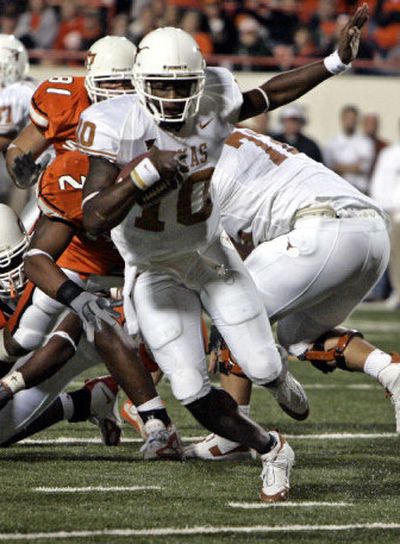
Texas quarterback Vince Young maneuvers through Oklahoma State's defense and into the end zone for a touchdown in the third quarter in Stillwater, Okla., on Saturday. The Longhorns overcame a 19-point deficit in Young's eighth career second-half comeback. 
 (Associated Press / The Spokesman-Review)
