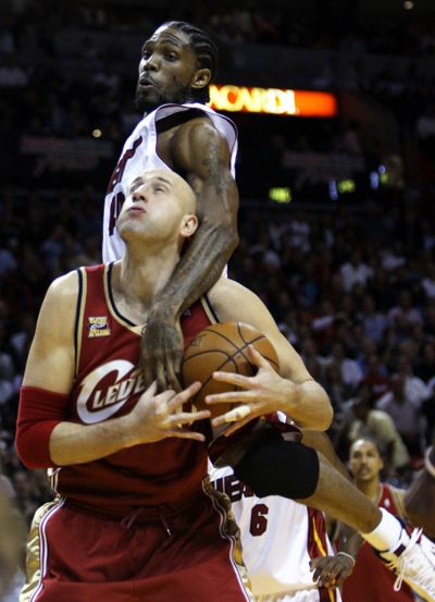 Cavaliers center Zydrunas Ilgauskas gets a hug and a foul from Udonis Haslem on Thursday. Cleveland defeated Miami 111-104. (Associated Press)