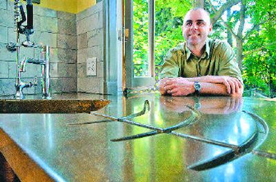 
Chris Oxford shows off the concrete countertop with a hollowed-out drainboard he created for his own kitchen remodel. 
 (Holly Pickett / The Spokesman-Review)
