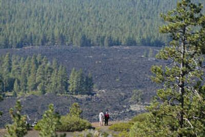 
Visitors view a lava flow from atop the 500-foot cinder cone at Newberry National Volcanic Monument south of Bend, Ore. It is one of hundreds of more than 400 