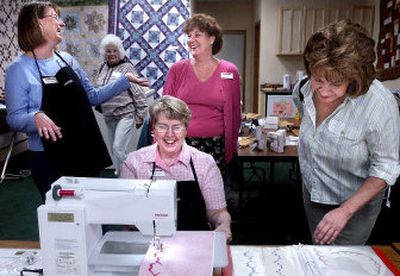 
Arless Scheet demonstrates new software on a sewing machine during a quilting class held at Bear Paw Quilting. Behind her, from left, are Kathryn Boss, in apron, talking to Sandy Goedde, co-owners of Bear Paw. At right is Yolanda Peak. 
 (Kathy Plonka / The Spokesman-Review)