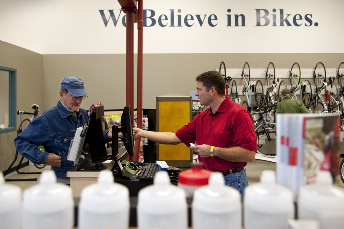 Two Wheel Transit’s Geoff Forshag, right, assists Kent Holbrook in buying chain lube Tuesday at the store at 817 S. Perry St. in Spokane. (Dan Pelle)