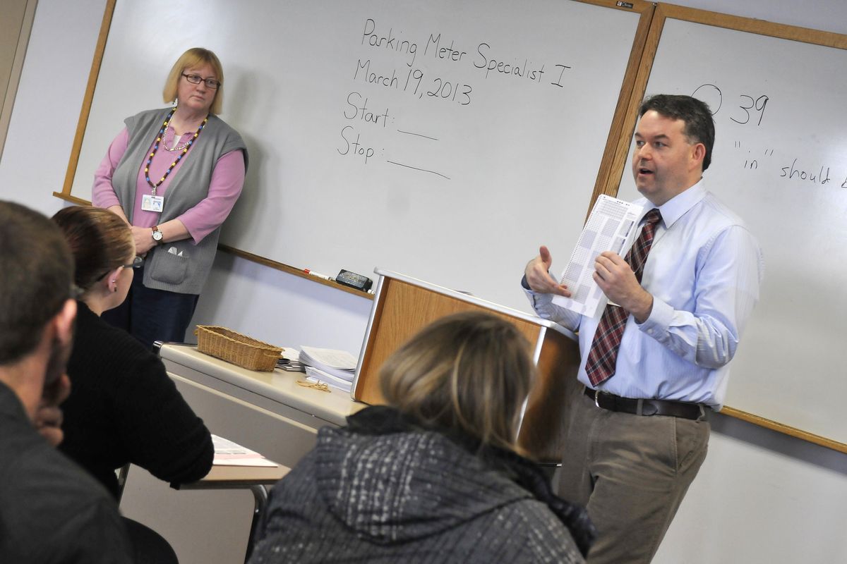 Bryan Sullivan, a Civil Service examination analyst, explains the format during a testing session March 19 at Spokane City Hall. The test was for a parking meter reader. Although there are no openings, test takers are placed on a hiring list that will be kept for two years. At left is Judy Destito, who helps supervise the testing sessions. (Jesse Tinsley)