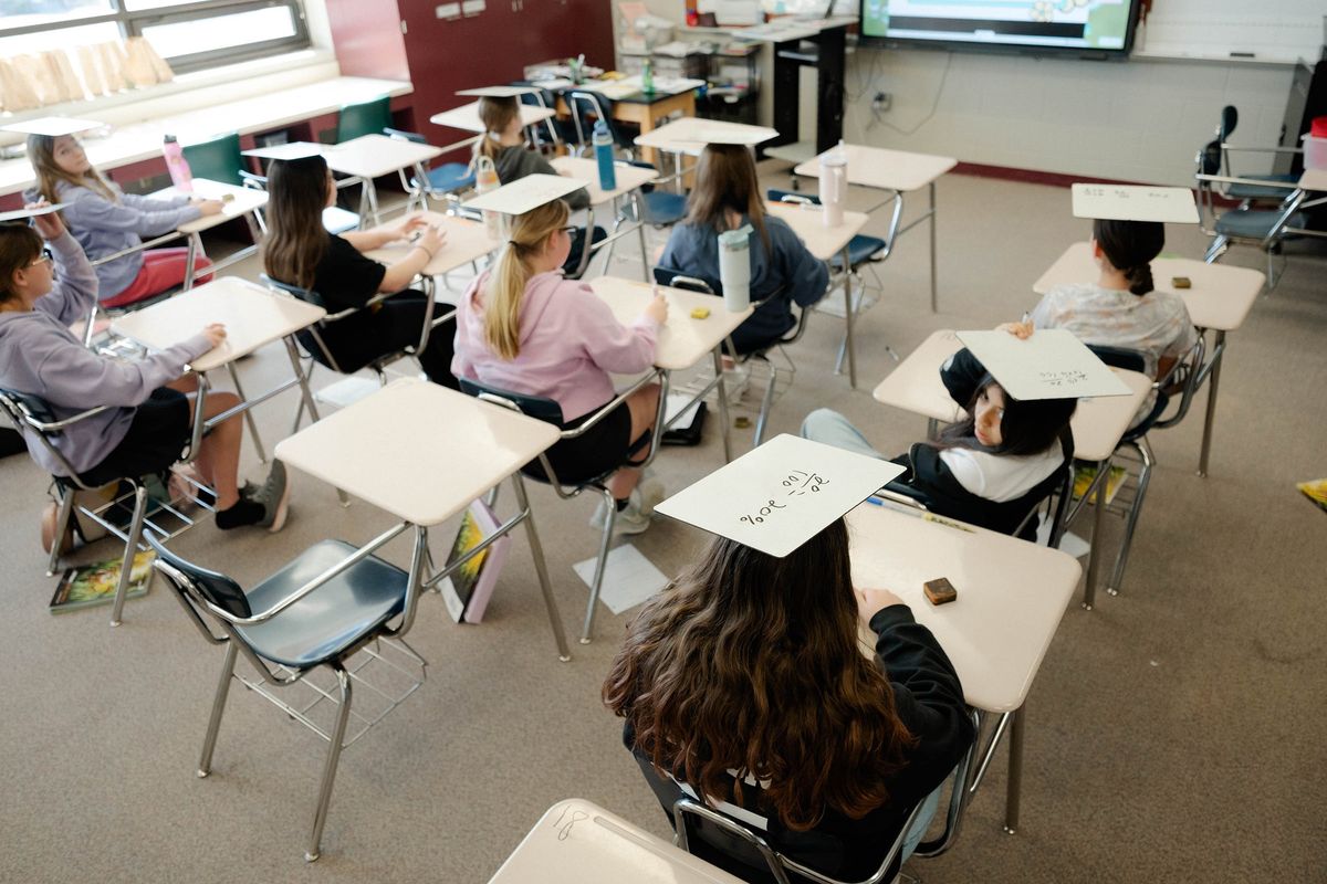 Students use whiteboards in math class at McPherson Middle School on Feb. 26 in McPherson, Kan. No more YouTube or video games on school laptops. Textbooks and pencils are back. Some seventh-graders say they prefer learning offline.  (DAVID ROBERT ELLIOTT)