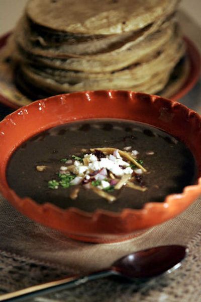 
Black bean tortilla soup starts with roasted vegetables and chicken stock. Then it's dressed up with cilantro, onion, roasted chilies and crunchy strips of fried tortillas. 
 (Los Angeles Times photos / The Spokesman-Review)