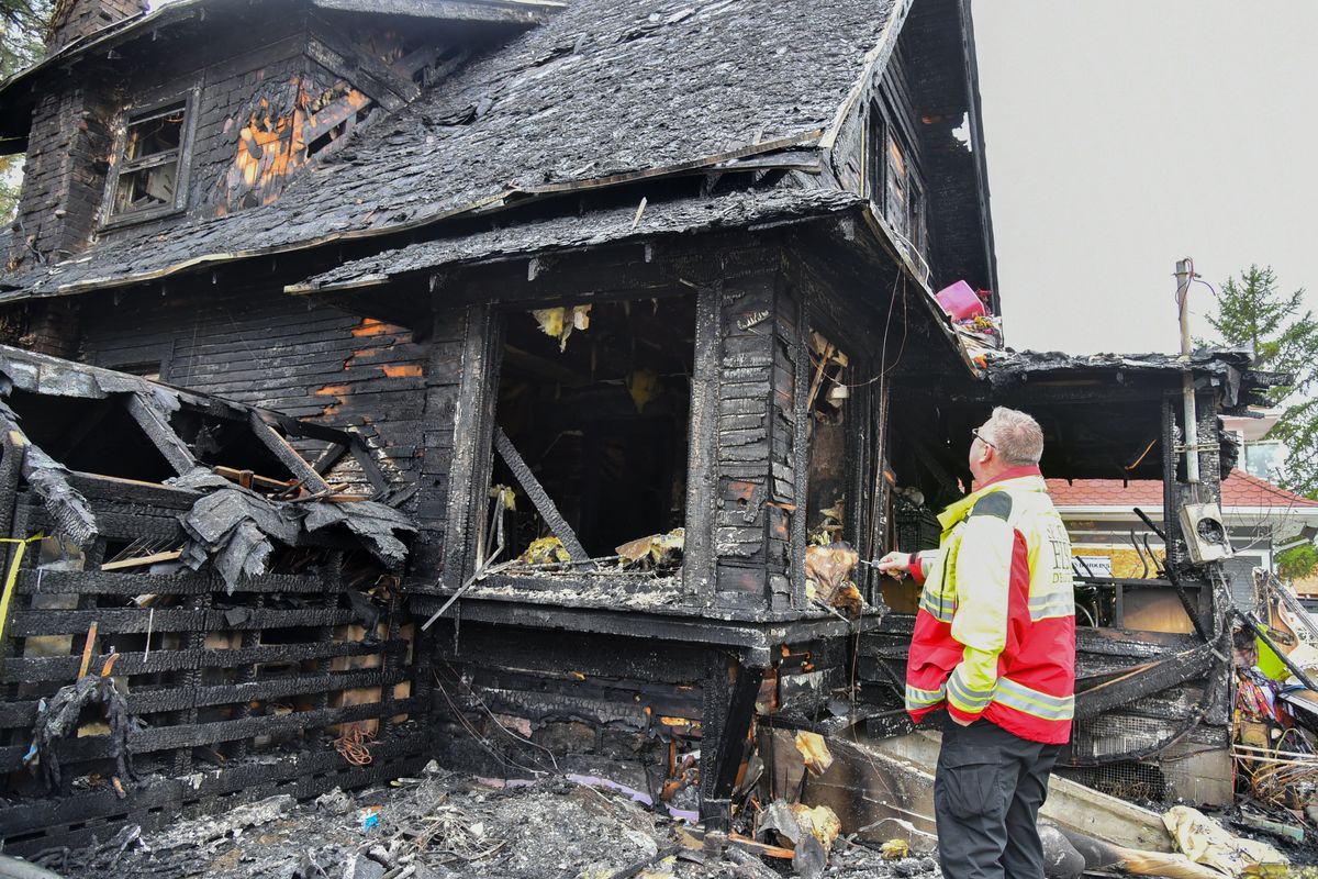 Division Chief and Fire Marshal Lance Dahl looks at the remains of the home at Lidgerwood and LaCrosse in North Spokane on Monday.  (Jesse Tinsley/The Spokesman-Review)