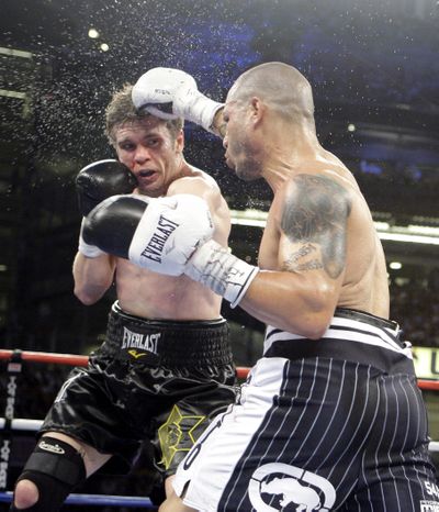 Miguel Cotto lands a right to the head of Yuri Foreman during the fifth round Saturday at Yankee Stadium.  (Associated Press)