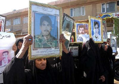 
Holding pictures of slain relatives, women in Najaf on Sunday demand the death penalty for Saddam Hussein. 
 (Associated Press / The Spokesman-Review)