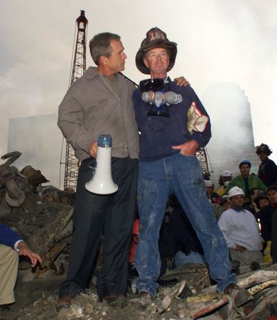 President George W. Bush embraces firefighter Bob Beckwith while standing in front of the collapsed World Trade Center buildings on Sept. 14, 2001. (Associated Press)