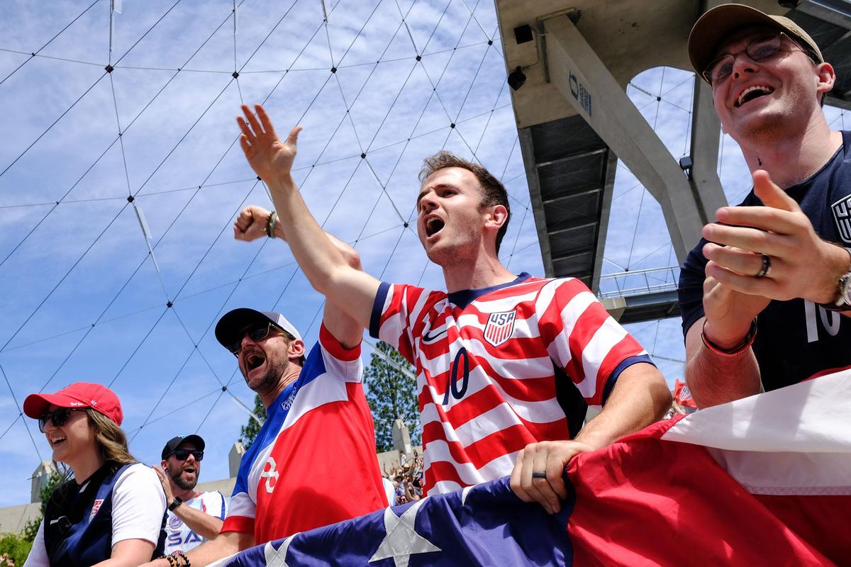 Sean Rovic, third from left, Matthew Mastronardi and Caleb Stuffle cheer Friday as USA scores a goal against Australia during a FIFA Men’s World Cup watch party at Gesa Pavilion in Spokane.  (Tyler Tjomsland/The Spokesman-Review)