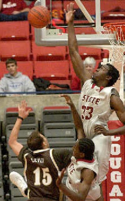 
Washington State's Ivory Clark blocks a shot with Wyoming's Steve Leven looking on. 
 (Associated Press / The Spokesman-Review)