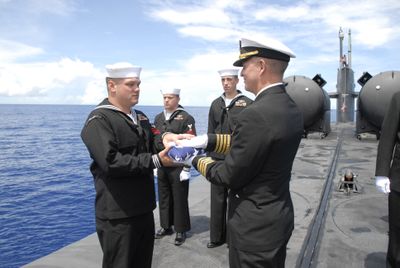 Machinist Mate 1st Class Jason Witty, of Puyallup, Wash., receives an American flag from USS Ohio commanding officer Capt. Dennis Carpenter during a burial ceremony at sea Oct. 2 for Witty’s grandfather, Eugene Morgan, who was a boatswain mate 2nd class aboard the USS Indianapolis when it sank in 1945. (Associated Press / The Spokesman-Review)