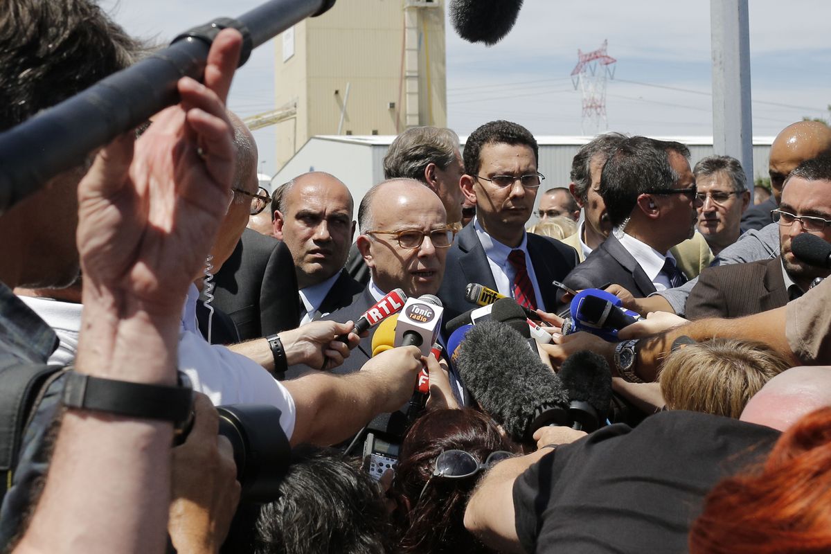 French Interior Minister Bernard Cazeneuve answers reporters after an attack took place, Friday, June 26, 2015 in Saint-Quentin-Fallavier, southeast of Lyon, France.  At least one man attacked a gas factory Friday in southeastern France, posting a severed head at the factory