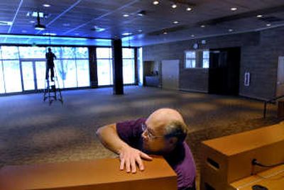 
Richard Pruett, front, of Bunkhouse Media of Coeur d'Alene, works to hook up the microphones in the new Coeur d'Alene City Council chambers in the Coeur d'Alene Library on Wednesday. 
 (Kathy Plonka / The Spokesman-Review)