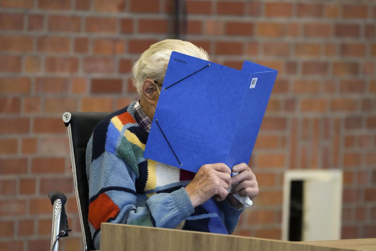 The accused Josef S. covers his face as he sits at the court room in Brandenburg, Germany, Thursday, Oct. 7, 2021. The 100-year-old man charged as an accessory to murder on allegations that he served as a guard at the Nazis