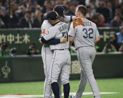 Seattle Mariners right fielder Ichiro Suzuki  hugs his teammate while leaving the field for a defensive substitution in the fourth inning  Wednesday against the Oakland Athletics at Tokyo Dome. (Koji Sasahara / AP)