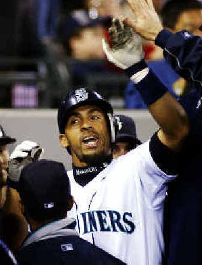 
Seattle's Hiram Bocachica is greeted in the dugout after his solo home run in the second inning on Saturday. 
 (Associated Press / The Spokesman-Review)