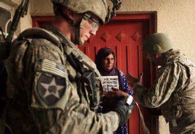 
An Iraqi woman is photographed by U.S. soldiers as they search a Baghdad neighborhood Sunday. Associated Press
 (Associated Press / The Spokesman-Review)