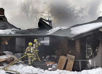 Fire District 8 firefighters work Wednesday to put out the second fire  at 4808 S. Dyer Road in two days.  (Christopher Anderson / The Spokesman-Review)