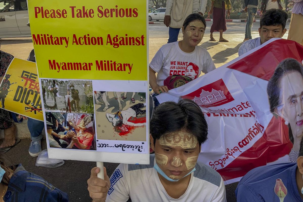 An anti-coup protester holds a placard requesting military action against Myanmar military in Yangon, Myanmar Thursday, Feb. 25, 2021. Protesters against the military