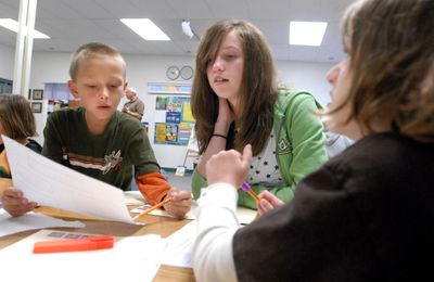 Noel Madsen, center, a seventh-grader at Continuous Curriculum School, helps second-graders Will Sharpe, left, and Natalie Donohue, right, at the school Thursday. CCS is a choice-in school in the East Valley District and is in the same building as Skyview Elementary.  (Jesse Tinsley / The Spokesman-Review)