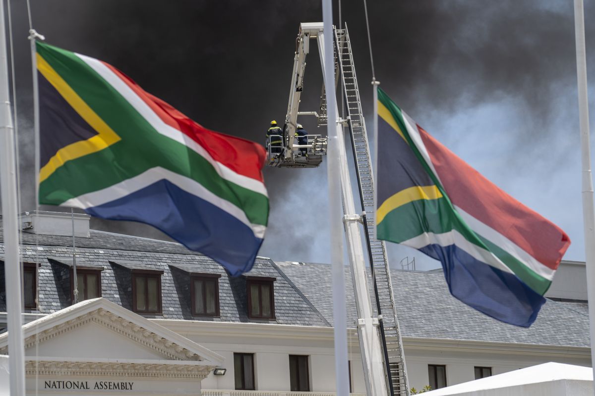 Firemen spray water on flames erupting from a building at South Africa