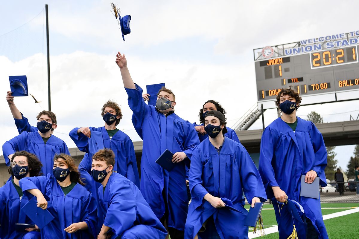 Jaden Baer, a senior at Mead High School, center, leads his friends in tossing their graduation caps for a photo set up by Mead yearbook teacher Makena Eusch during a special graduation ceremony for Baer on Thursday, April 22, 2021, at Union Stadium in Mead, Wash. After Baer was has spent the least year in treatment for terminal brain cancer and was recently diagnosed with a potentially fatal blood clot in his heart, the Mead school district decided to hold an early ceremony for Baer and his closest friends.  (Tyler Tjomsland/The Spokesman-Review)